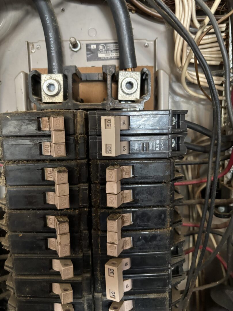Electrical panel with multiple circuit breakers.