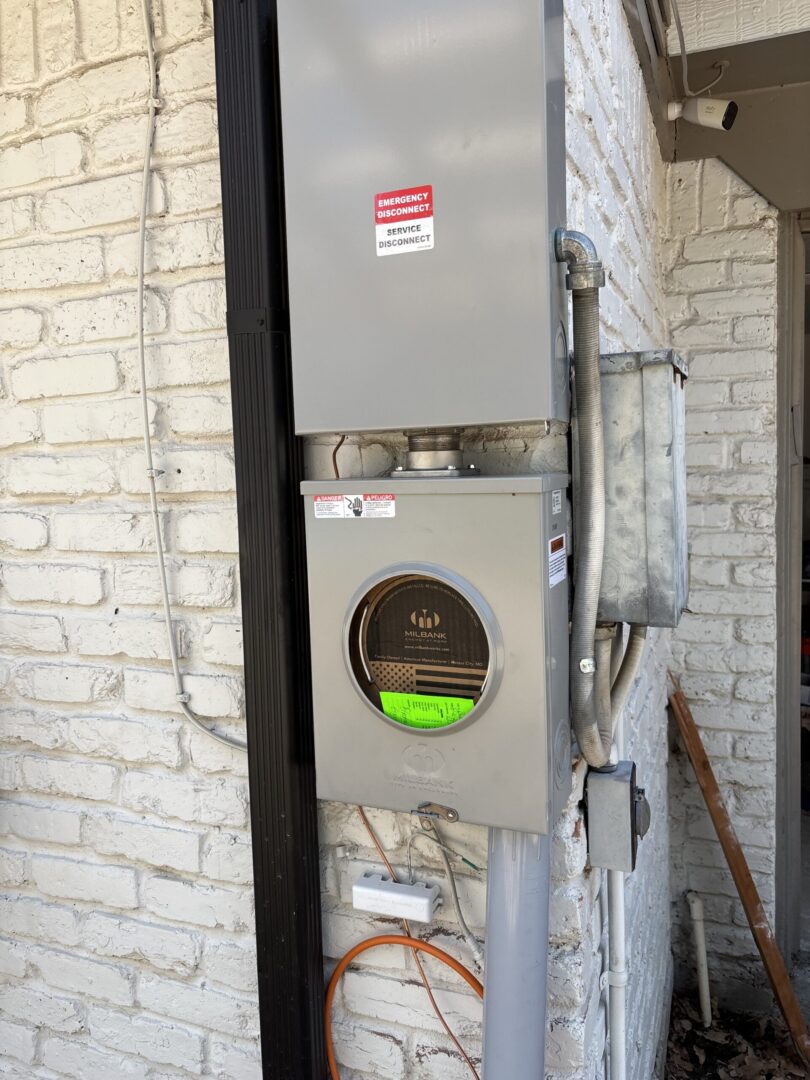 Electric utility meter on brick wall.