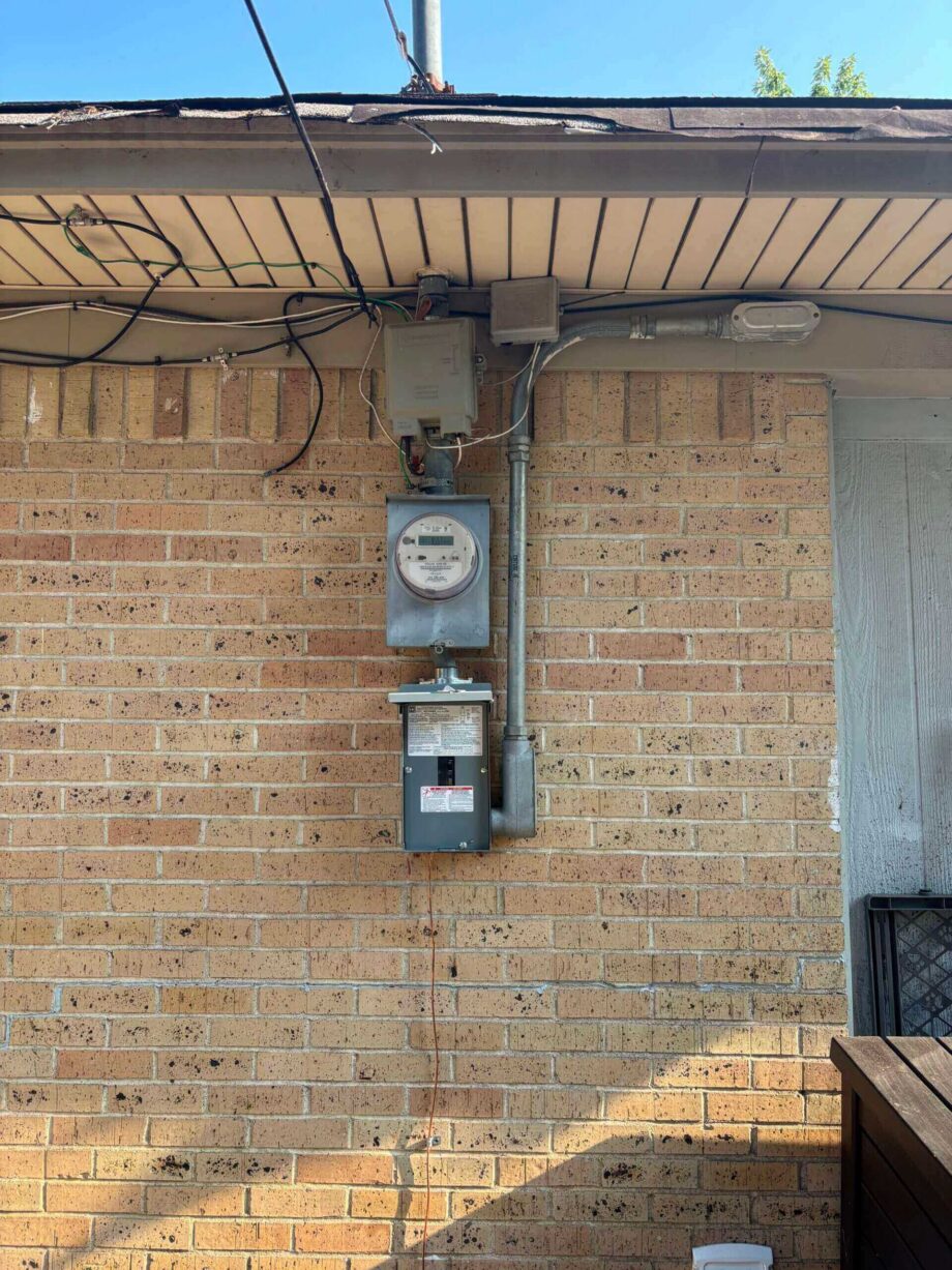 Electric meter on a brick wall exterior.