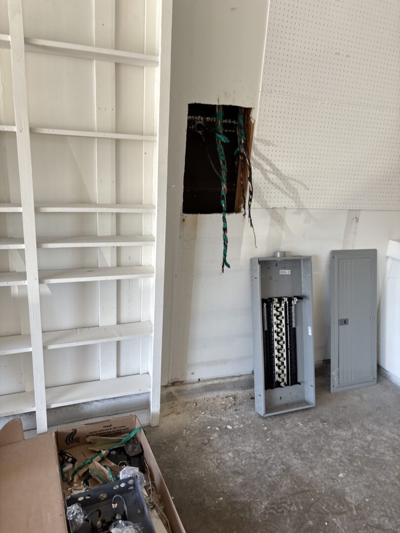 Electrical panel installation in progress, wires exposed.